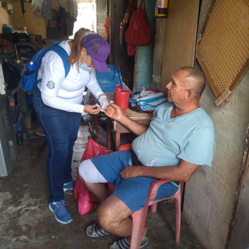 Experiencia Profesional de la Fundación toma una muestra a un habitante durante una jornada de detección de dengue.